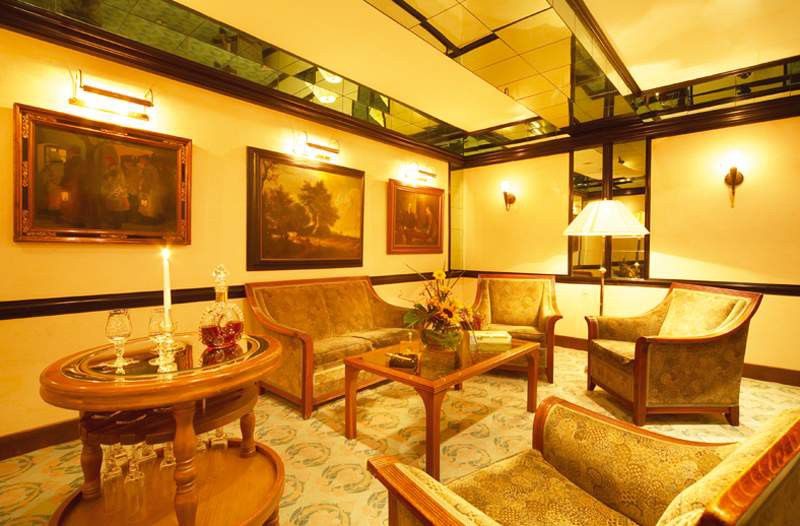 Art Nouveau Palace Hotel Praha Interior foto The photo depicts a cozy and elegantly furnished lounge area. It features several comfortable chairs and a sofa, all arranged around a central wooden coffee table. A decorative arrangement of flowers sits on the table, adding a touch of color to the 